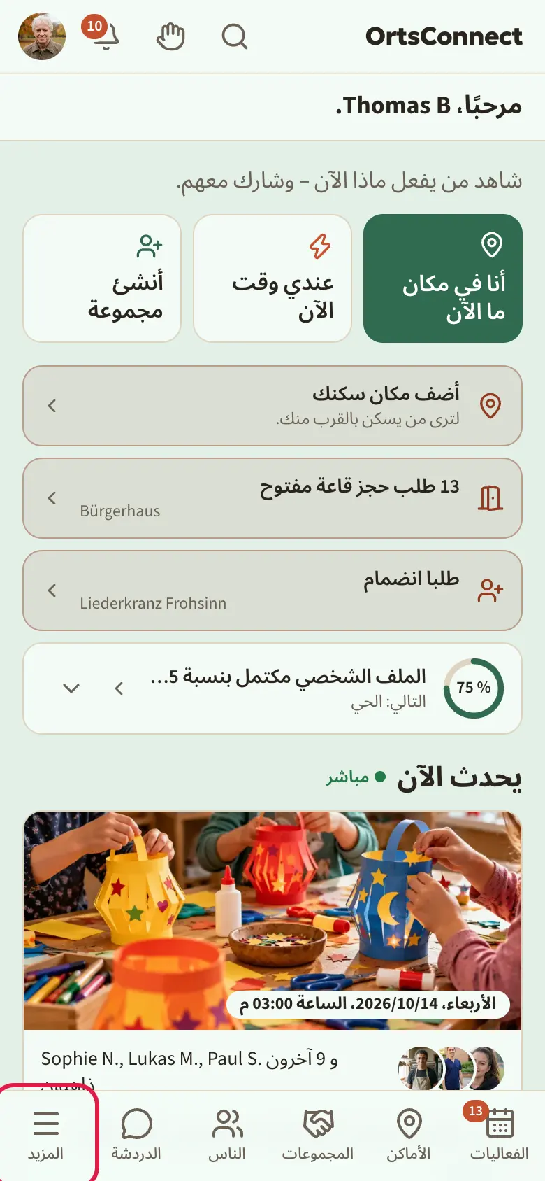 الصفحة الرئيسية على الهاتف مع السطر العلوي (الشعار، البحث، الجرس، الصورة الرمزية)، وشريط «منظماتي» وشريط التبويبات في الأسفل؛ مع تحديد «المزيد» (هناك توجد الجمعيات)