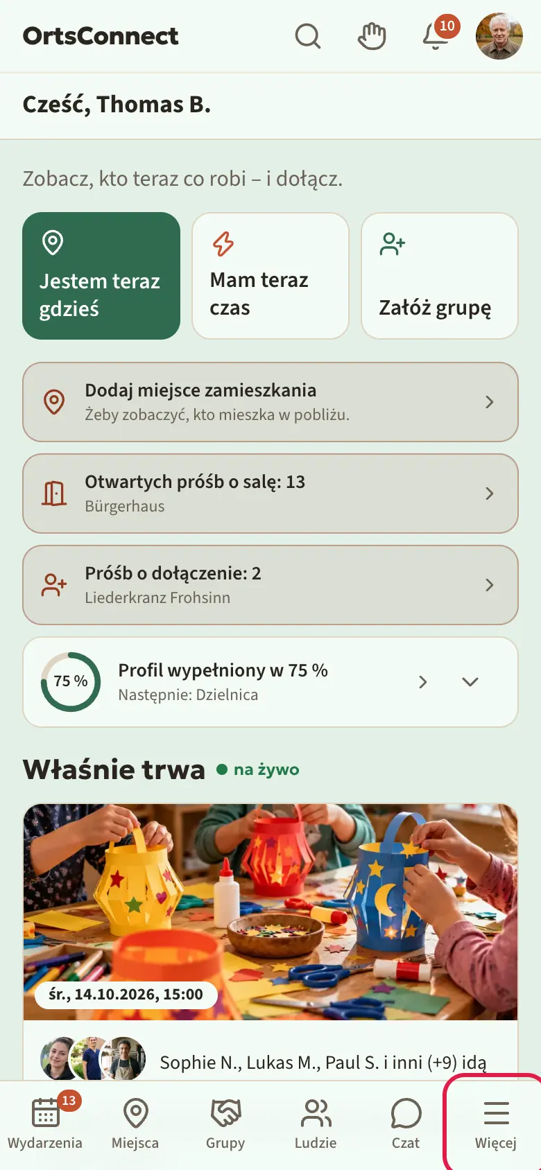 Strona startowa na telefonie z górnym paskiem (logo, wyszukiwanie, dzwonek, awatar), paskiem „Moje organizacje” i paskiem zakładek na dole; zaznaczone „Więcej” (tam są stowarzyszenia)
